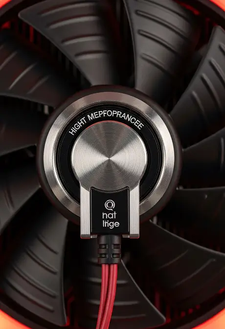 Close-up of a black computer fan with a central silver hub and red cables connected.